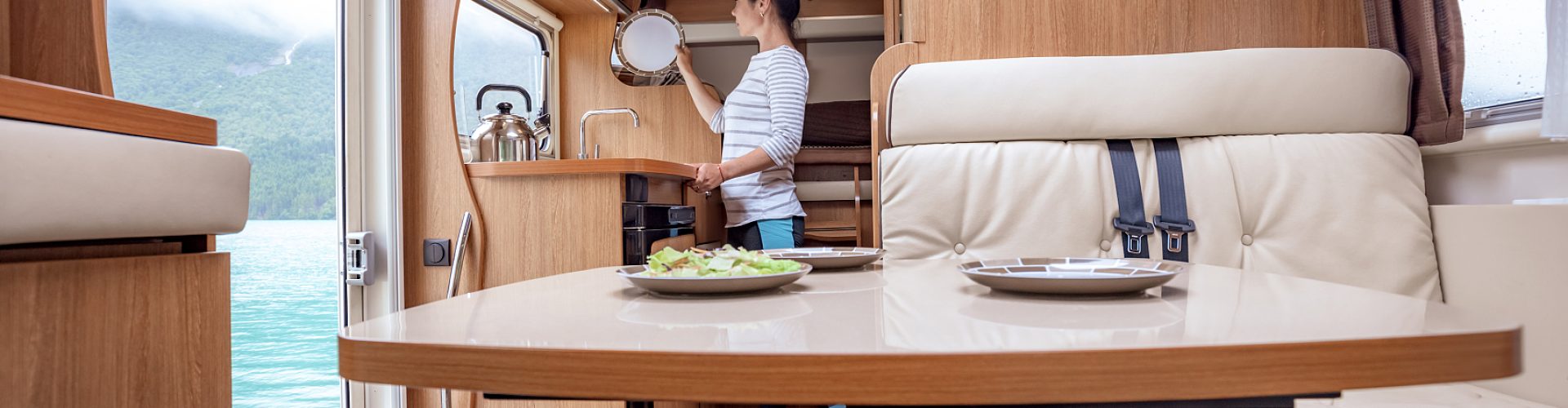 Woman cooking in camper, motorhome RV interior. Family vacation travel, holiday trip in motorhome, Caravan car Vacation.