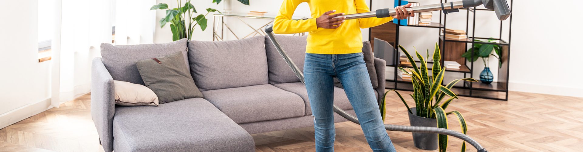 Happy woman cleaning home with vacuum cleaner and listening music - Housewife doing her homeworks, domestic life scene