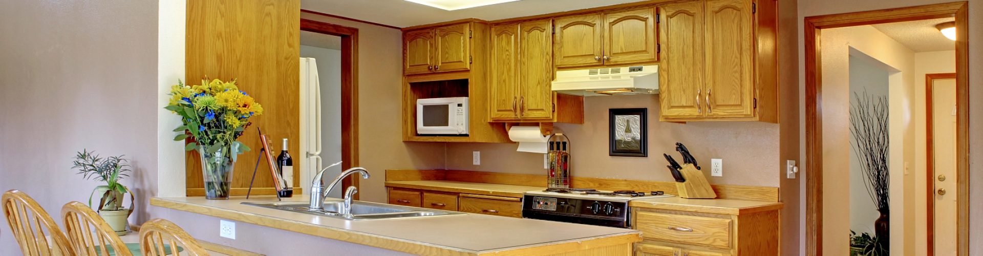 House interior with open floor plan. Kitchen with maple cabinets and bar counter